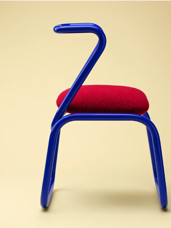 FLUX 3 product rendering sample — sculptural blue chair with red cushion, studio lighting